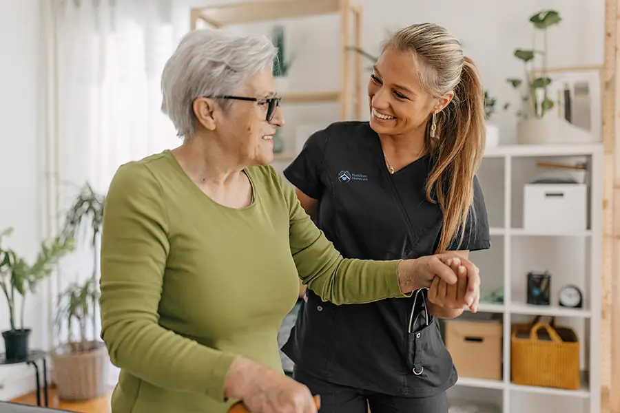 Caregiver helping senior client walk